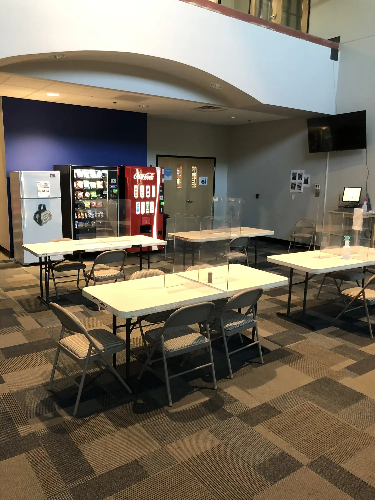 An office break room with tables and vending machines.